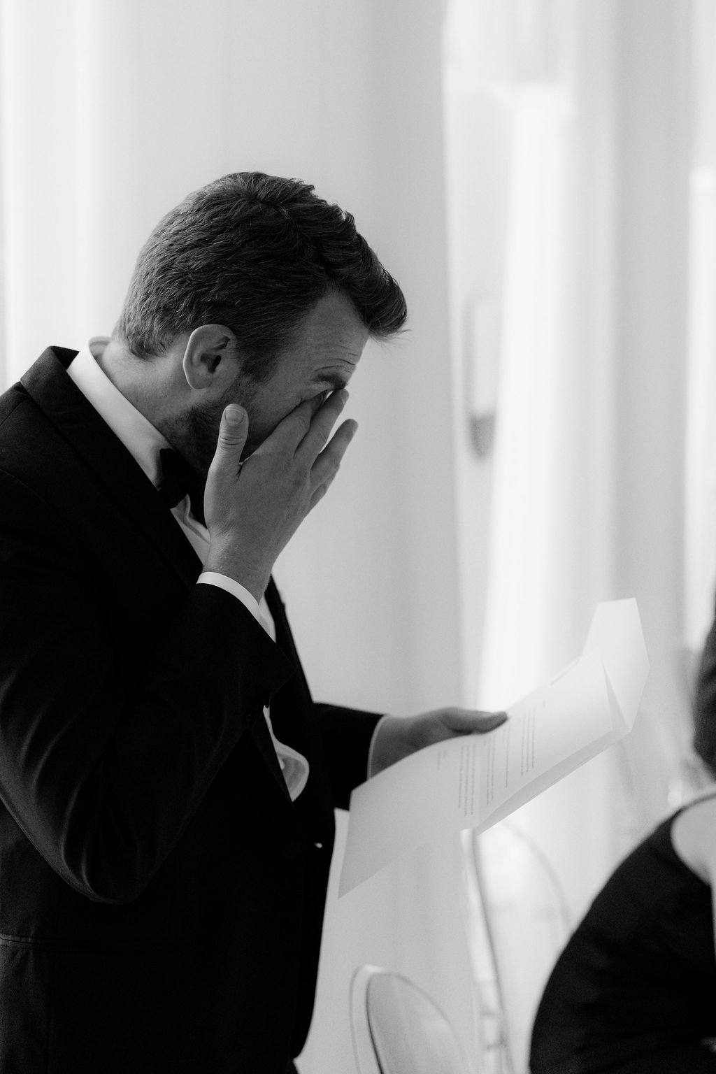 Hochzeitsgast öffnet einen personalisierten, handgefertigten Umschlag aus Baumwollpapier mit kalligrafiertem Brief
