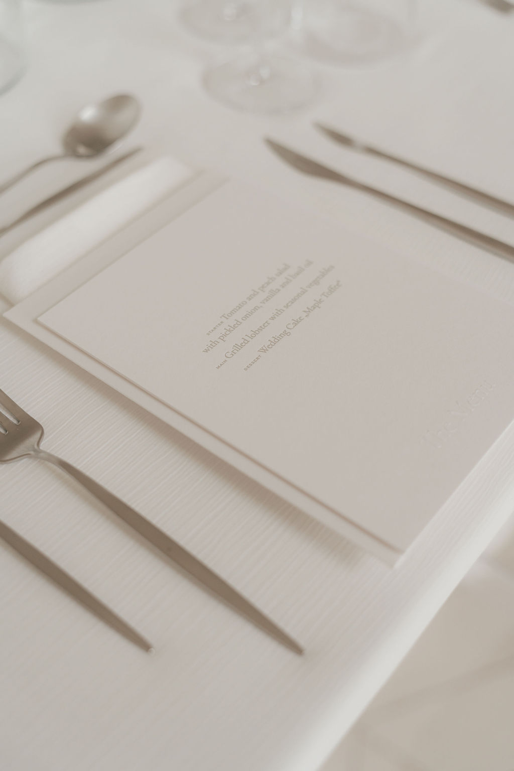Dinner-Menükarte im Letterpress auf Baumwollpapier mit geprägtem Titel am Gedeck