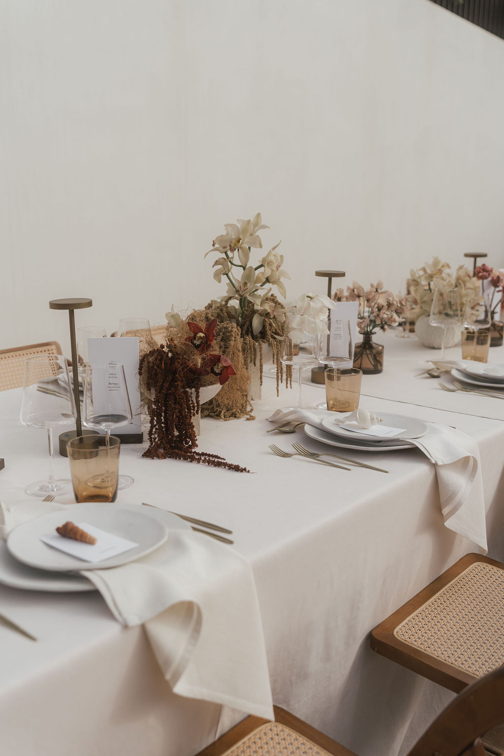 Elegant gedeckter Tisch mit Letterpress-Menükarte auf Holzständer und Platzkarten mit Muscheln