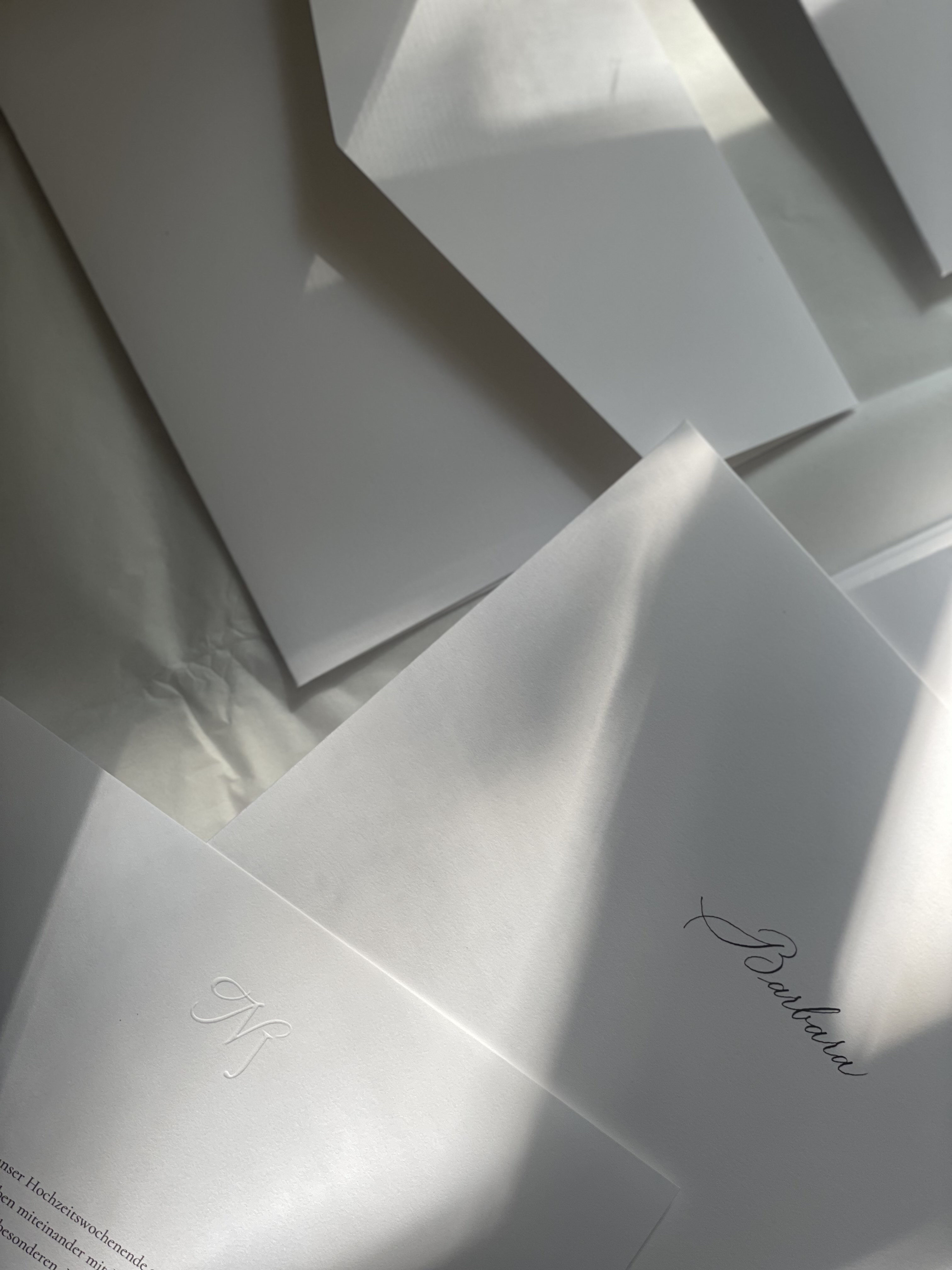 Handgefertigte Umschläge aus Baumwollpapier mit blindgeprägtem NJ-Monogramm und dem von Hand kalligrafierten Gästenamen Barbara